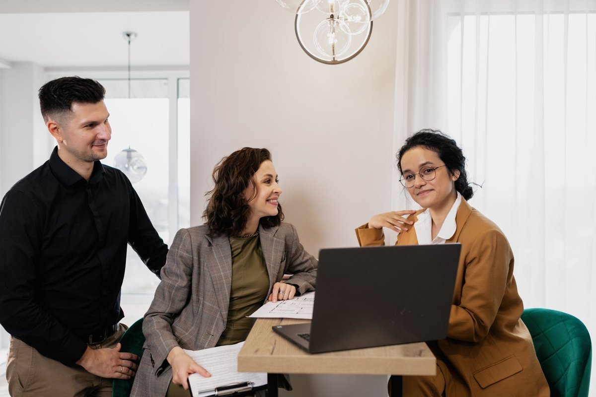 Consultant walking two clients through material on a laptop