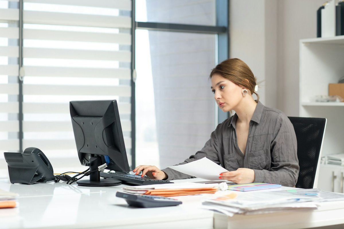 Campus administrator working through paperwork at an office desk