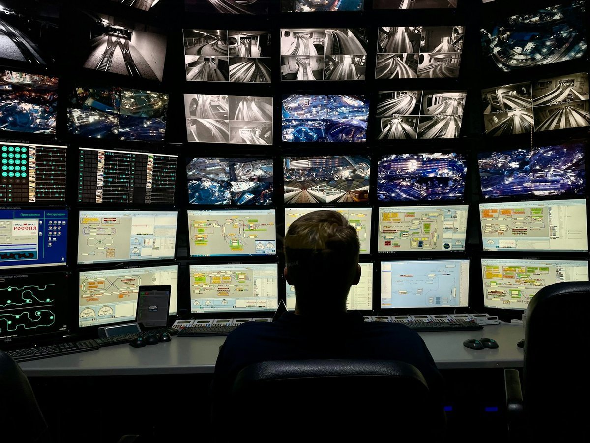 Operator monitoring a wall of control room screens