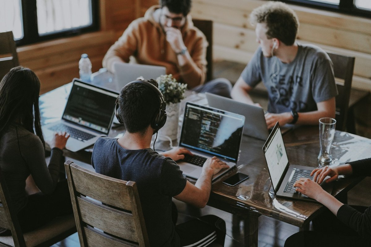 Development team working together on laptops around a shared table