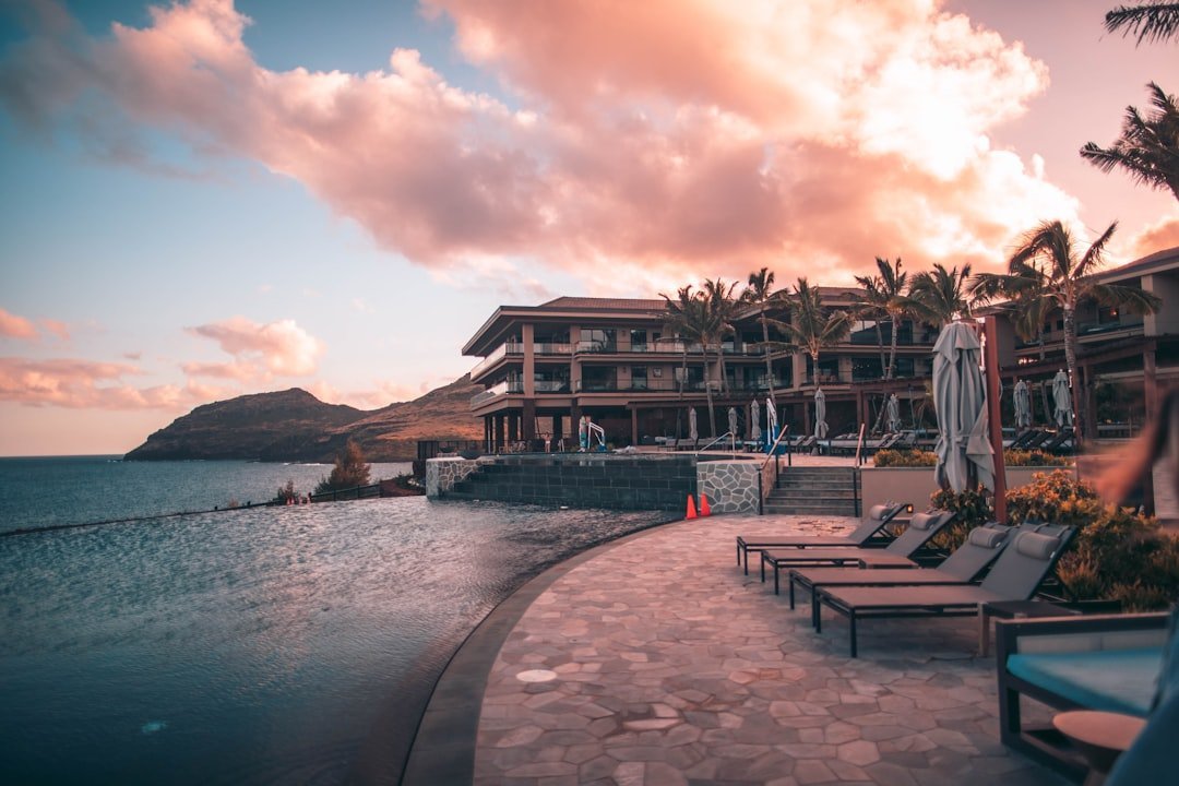 Resort infinity pool and villas at dusk beside the ocean