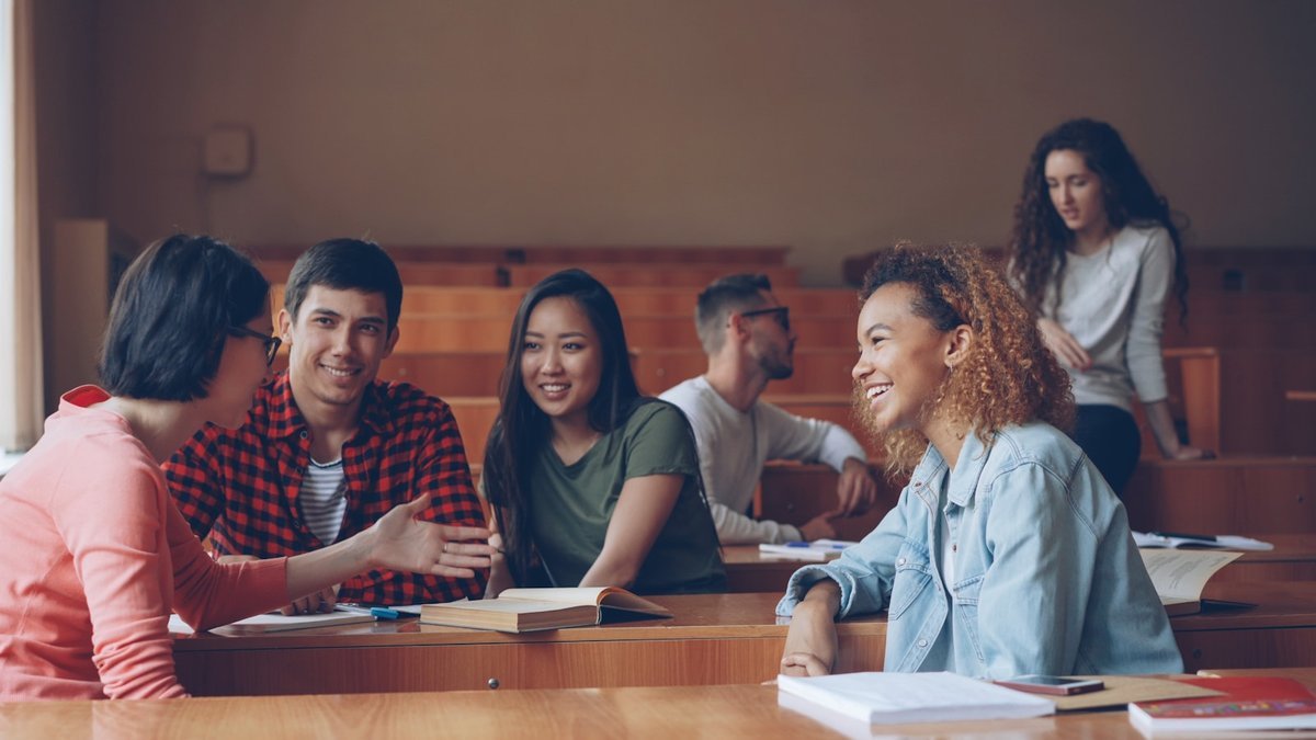 Advisor listening to a student across a table in a one-to-one meeting
