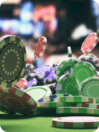 Casino poker chips falling on a green table.