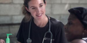 Smiling female doctor with stethoscope consulting patient.
