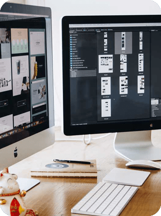 Dual monitors displaying digital designs on a desk.