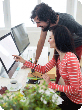 Coworkers collaborating, pointing at a computer screen.