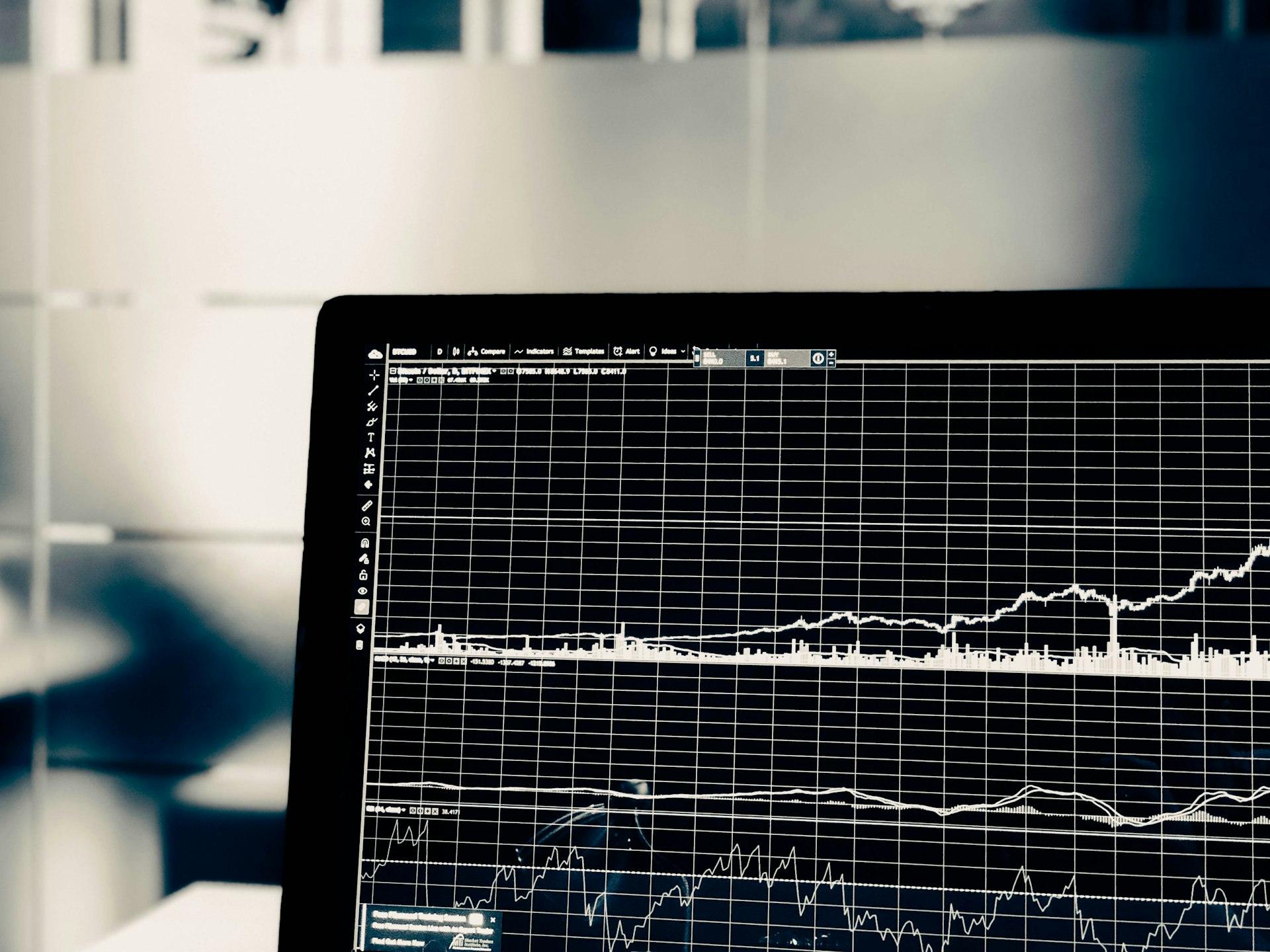 Laptop screen showing financial charts and graphs.