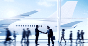 Businessmen shaking hands at airport with airplane outside.